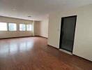 Spacious living room with wooden floors and large windows