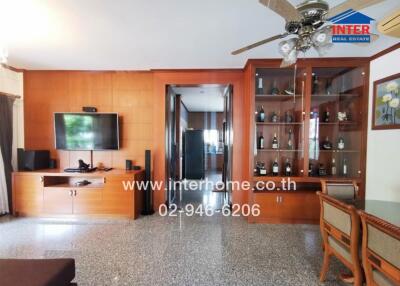 Spacious living room with wooden cabinetry and glass shelving