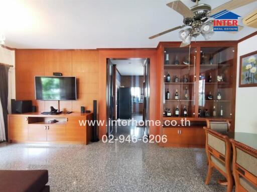 Spacious living room with wooden cabinetry and glass shelving