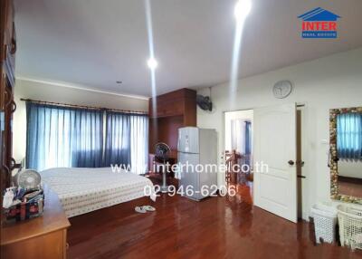 Spacious bedroom with wooden floors, large bed, and modern amenities