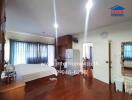 Spacious bedroom with wooden floors, large bed, and modern amenities