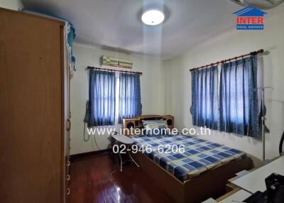 Bedroom with bed, shelves, and windows with blue curtains