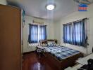 Bedroom with bed, shelves, and windows with blue curtains