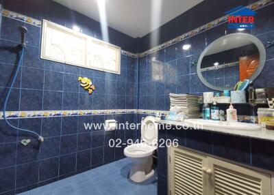 Modern bathroom with blue tiles and various accessories