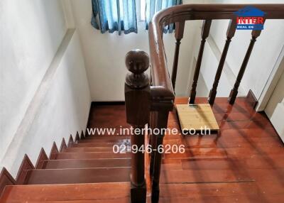 View of wooden staircase with railing