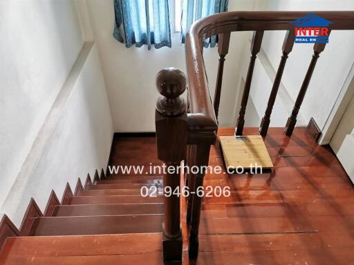 View of wooden staircase with railing