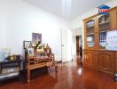 Well-lit living room with a wooden floor and a decorative cabinet