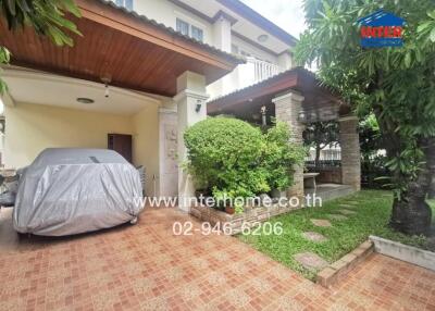 Covered parking area in front of a house with a garden