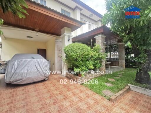 Covered parking area in front of a house with a garden