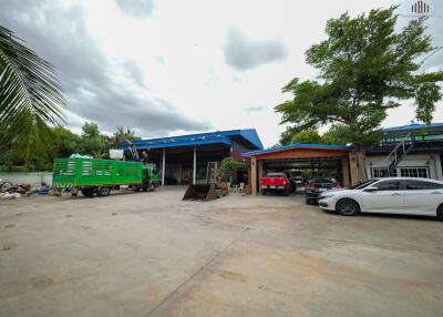 Exterior view showing parking area with various vehicles and trees