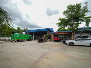 Exterior view showing parking area with various vehicles and trees