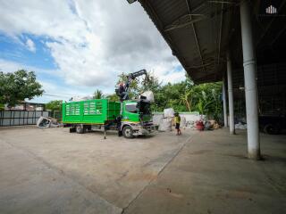 Commercial lot with truck and crane unloading materials