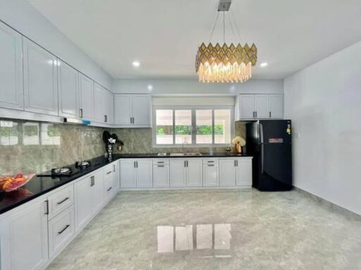 Modern kitchen with white cabinets and black countertops