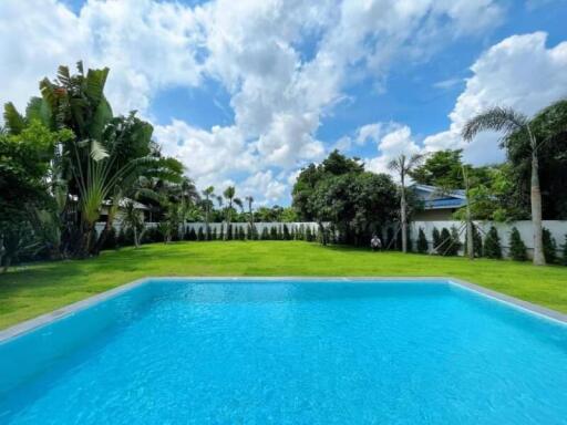 Backyard with swimming pool and lush green lawn