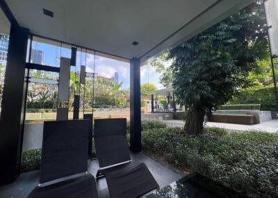 Covered outdoor seating area with plants and pool view