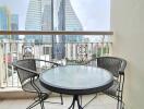 Outdoor balcony area with a round glass table and two chairs