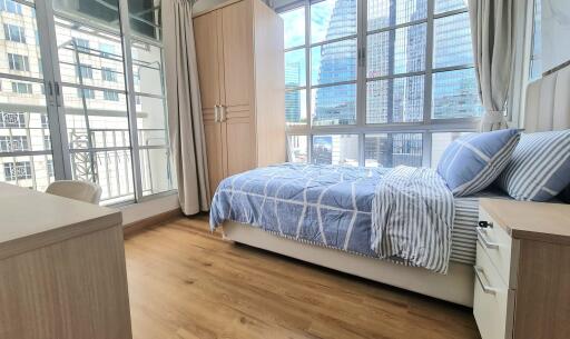 Modern bedroom with large windows and city view