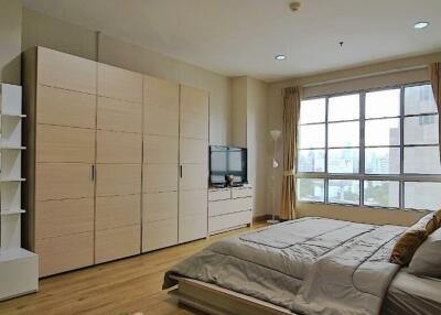 Spacious bedroom with modern furnishings and large window