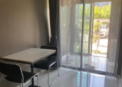 Small dining area with a table and two chairs next to a glass door leading outside