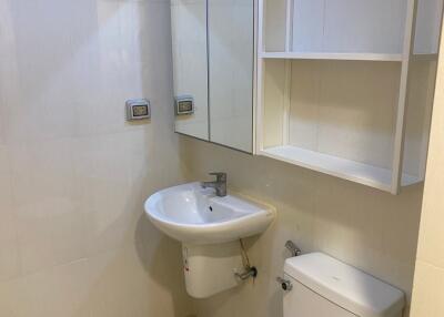 Modern bathroom with sink, toilet, and storage shelves