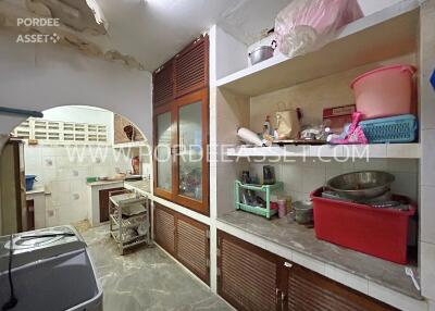 A cluttered kitchen with various items on the shelves