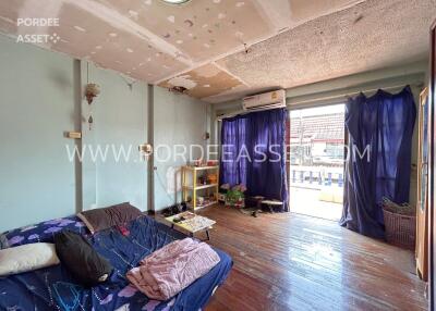 Living room with wooden flooring and exposed ceiling repairs