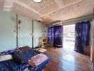 Living room with wooden flooring and exposed ceiling repairs