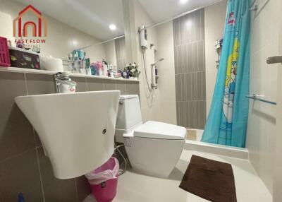 Modern bathroom with sink, toilet, shower, and various toiletries