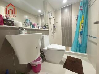 Modern bathroom with sink, toilet, shower, and various toiletries