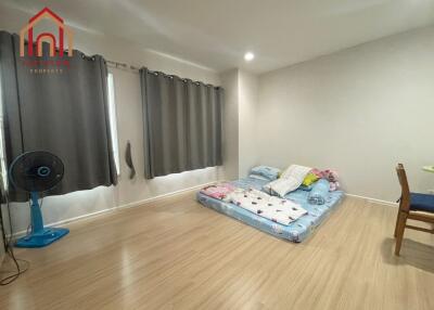 Minimalist bedroom with floor mattress and fan