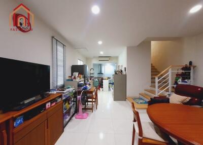 Modern living area with TV, dining set, and staircase