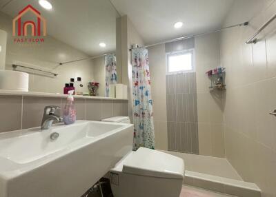 Modern bathroom with sink, toilet, shower, and colorful shower curtain