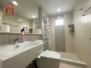 Modern bathroom with sink, toilet, shower, and colorful shower curtain