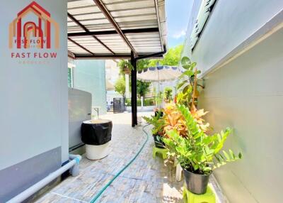 Covered outdoor walkway with plants and seating