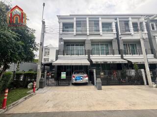 Three-story residential building with a car parked in front