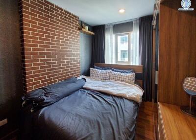 cozy bedroom with brick accent wall and large window