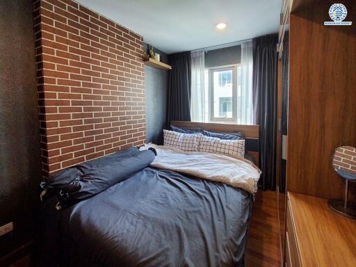 cozy bedroom with brick accent wall and large window