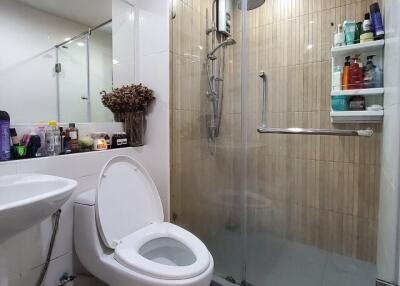 Modern bathroom with toilet, sink, and shower