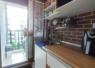 Compact modern kitchen with appliances and a balcony view