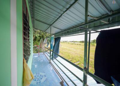 Covered balcony with hanging clothes and scenic view