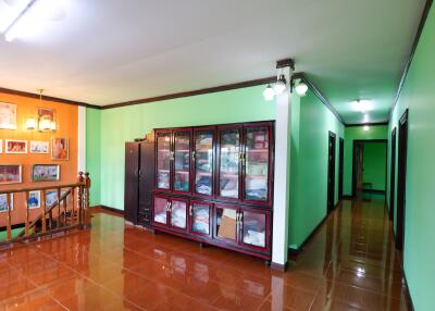 Spacious hallway with green walls and wooden floor