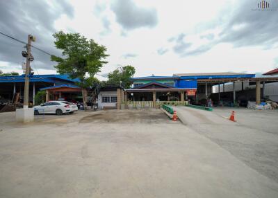 Front view of a building with various structures and parking area