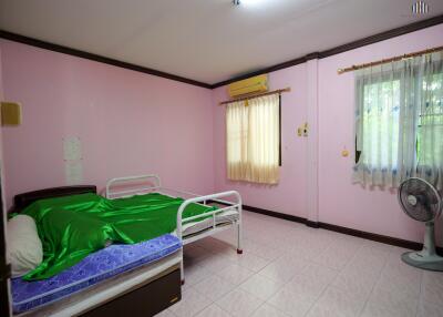 Bedroom with pink walls, bed, and window