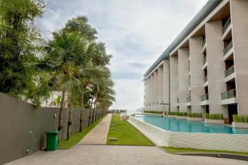 Modern apartment building with pool and palm trees