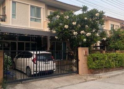 Two-story house with a carport and garden