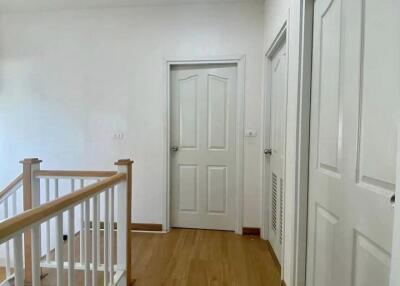 Spacious hallway with wooden flooring and multiple doors