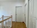 Spacious hallway with wooden flooring and multiple doors