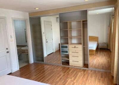 Spacious bedroom with wooden flooring, large mirrored closets, and an ensuite bathroom.