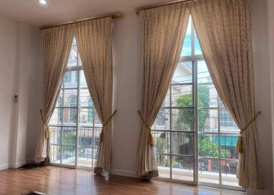 Bright living room with large floor-to-ceiling windows and elegant curtains