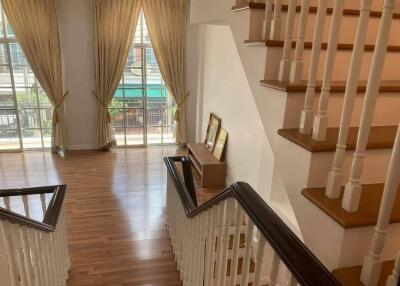 Spacious living area with staircase and large windows